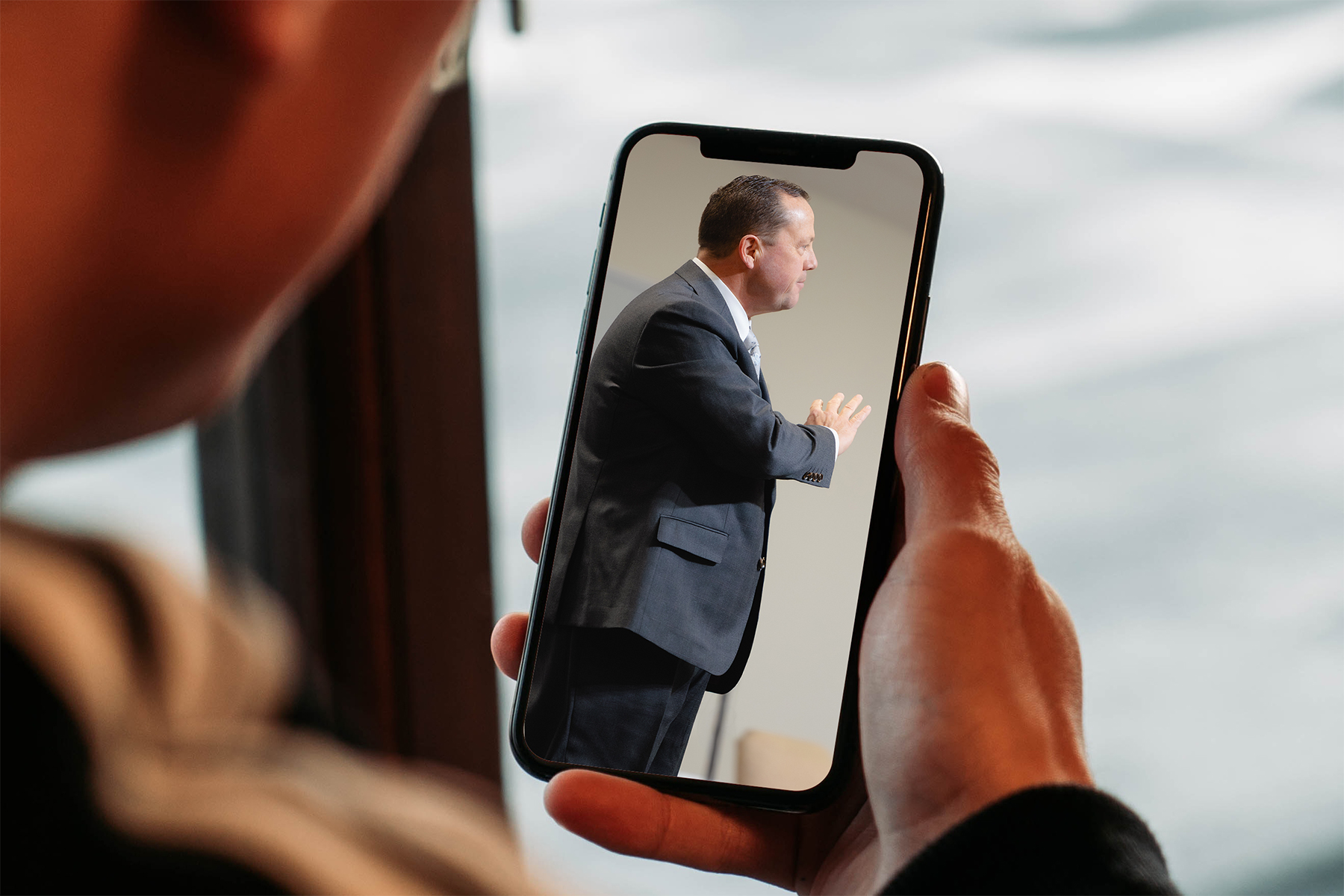 person watching a church sermon on a smartphone
